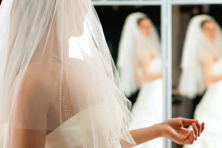 Bride at the clothes shop for wedding dresses; she is choosing a dress