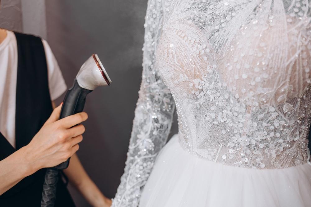 Women Ironing wedding dresses in studio by Ironing machine. Wedding concept.