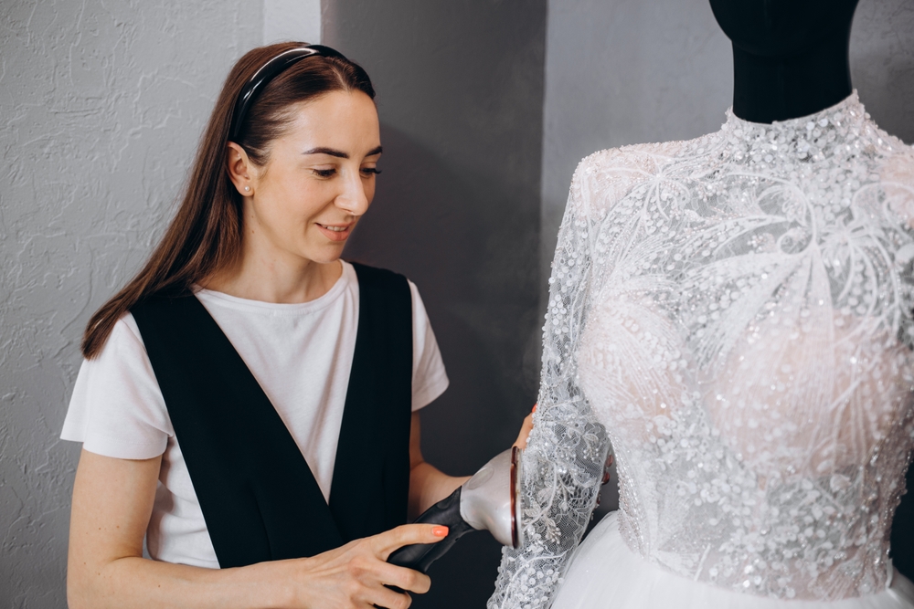 Women Ironing wedding dress in studio by Ironing machine. Wedding concept.